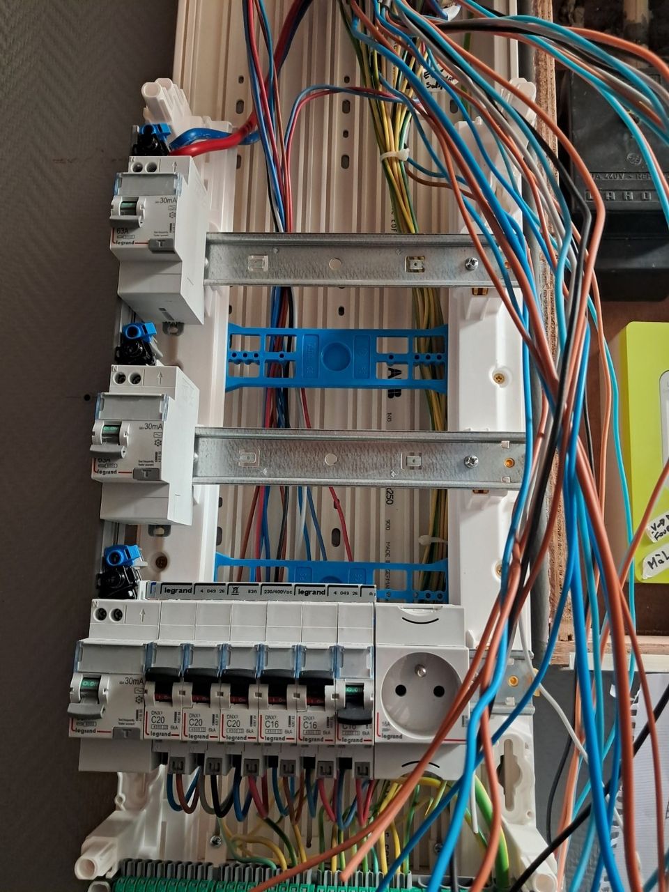 Vue d'ensemble montrant la complexité et l'échelle du câblage électrique en suspens devant un tableau principal ouvert lors d'un grand chantier de rénovation d'une maison ancienne à Armentières - par JC DOUAY Electricité
