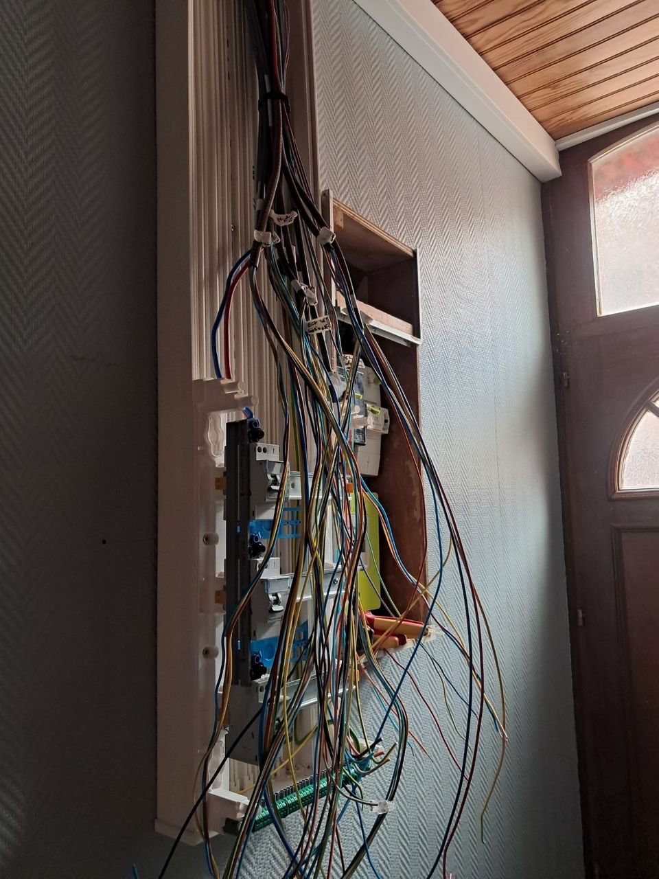 Gros plan sur le câblage complexe d'un nouveau tableau électrique en cours d'installation à Armentières, mettant en évidence la quantité de fils suspendus et un unique différentiel avant l'intégration finale - par JC DOUAY Electricité